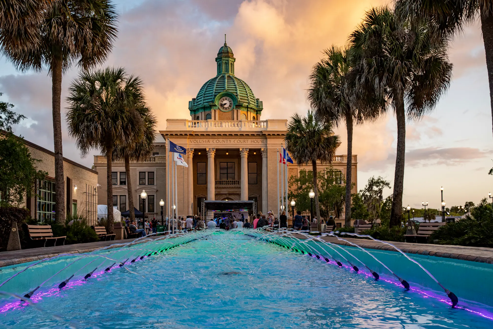The Volusia County Court House in DeLand, Florida, at sunset, with palms and a fountain in front