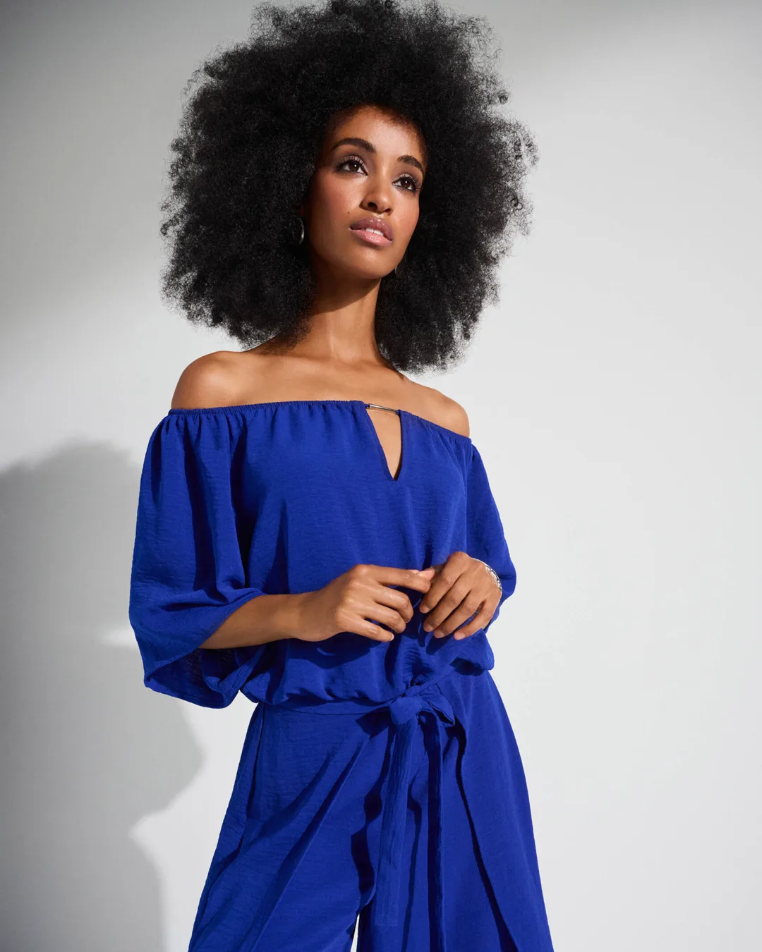 A model in a cobalt Joseph Ribkoff jumpsuit