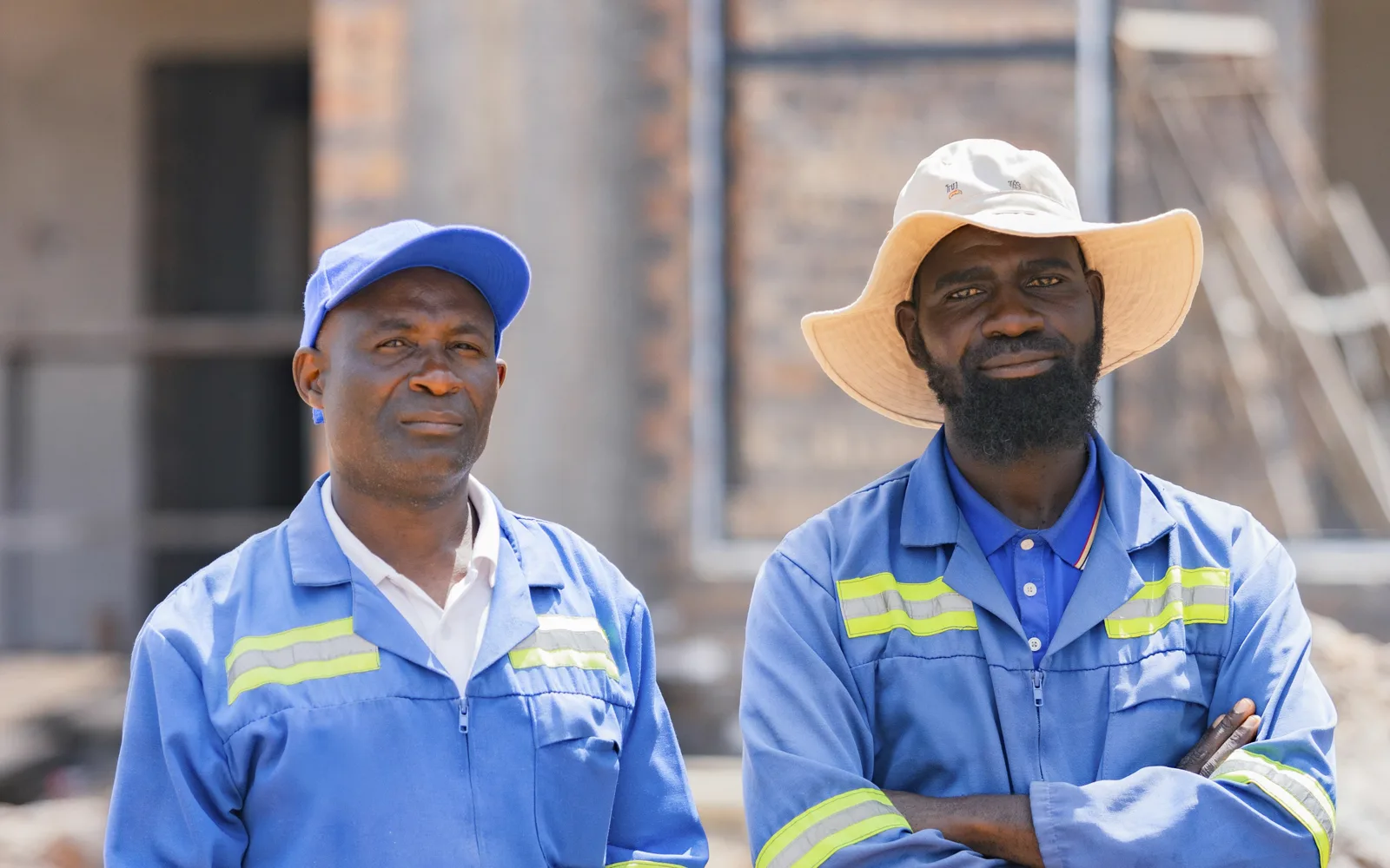 Two contractors in overalls on a building site: licensed stock, as used in the tender ads